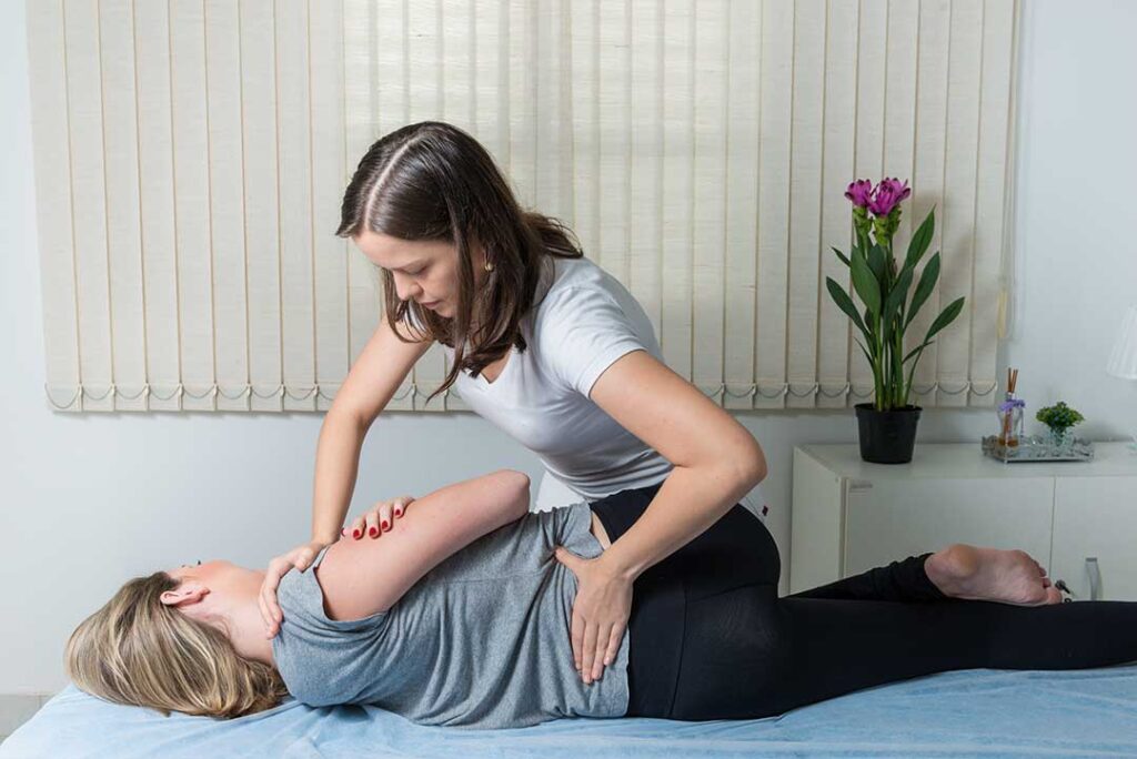 An older adult receives a gentle spinal adjustment from a chiropractor in a well-lit clinic setting.